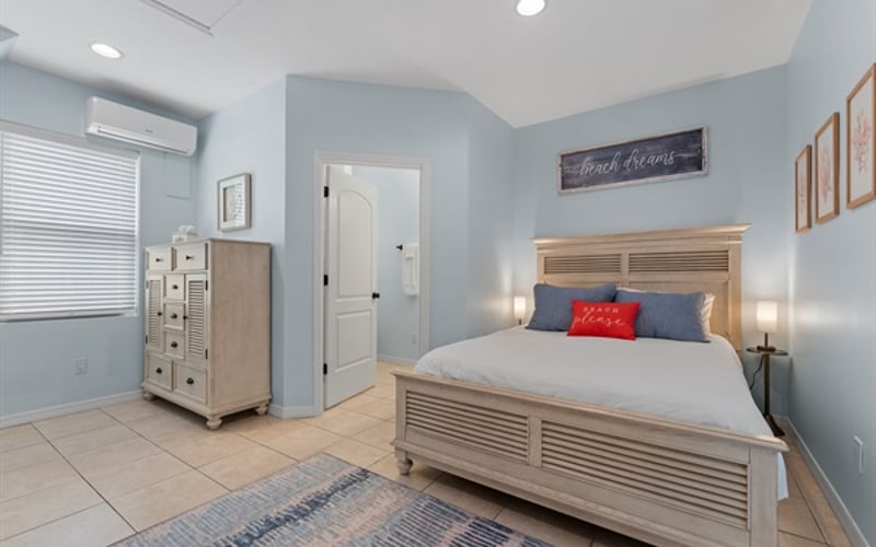 Main level ensuite queen bedroom with smart TV + direct access to pool.