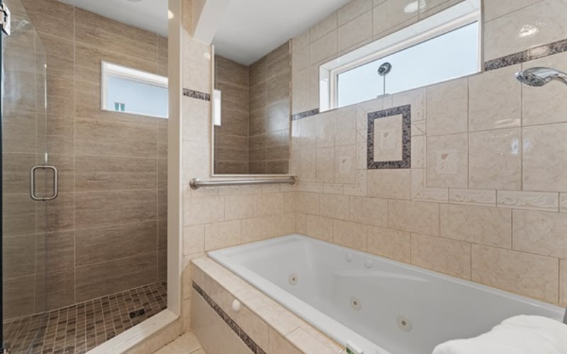Gorgeous, roomy master ensuite bathroom with a walk-in shower featuring dual showerheads and a large soaking bathtub, perfect for relaxing at day's end.